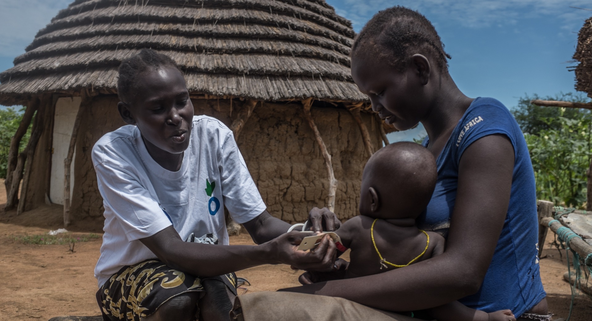 Agawol serves as an Action Against Hunger volunteer in her community. Here, she screens her neighbor's child for malnutrition.